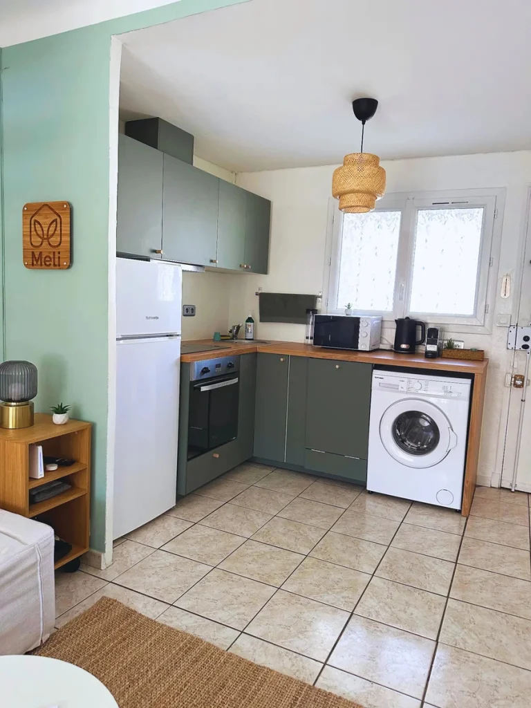 Cuisine vert sauge avec lave-linge et plan de travail en bois, projet Gouffé par Maison Solthée, architecte d'intérieur à Marseille