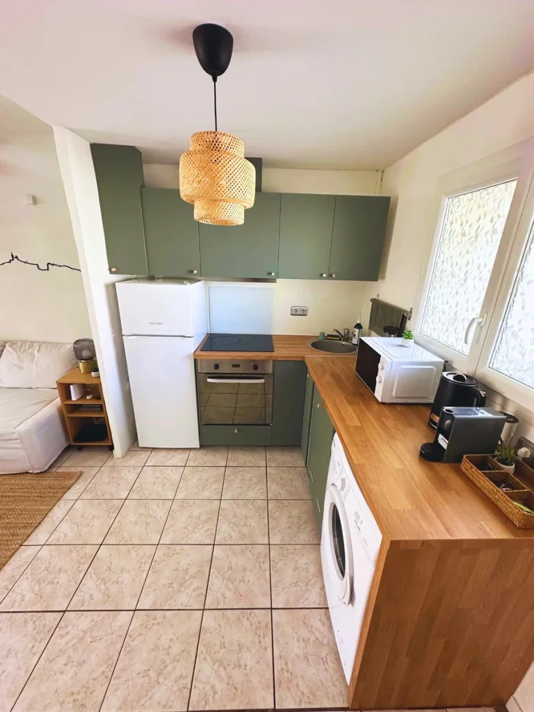 Cuisine vert sauge avec plan de travail en bois et réfrigérateur blanc, projet Gouffé par Maison Solthée, architecte d'intérieur à Marseille