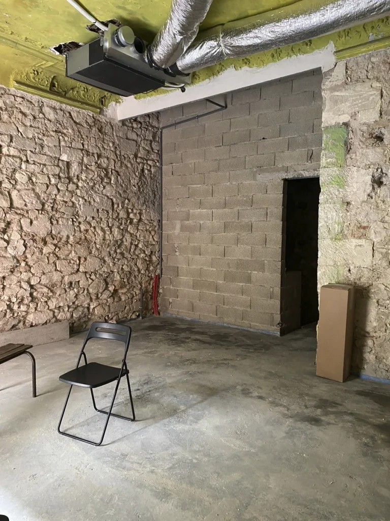 Local vide avant aménagement, mur en pierre et parpaings, chaise pliante, projet Meinado par Maison Solthée, architecte d'intérieur à Marseille