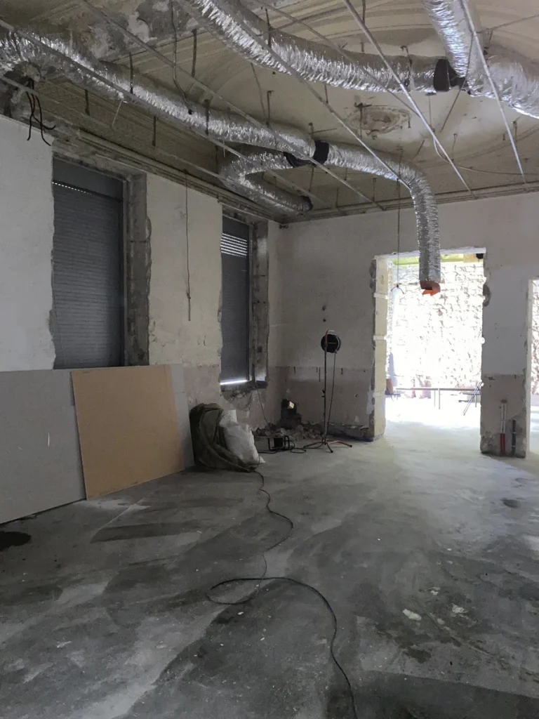 Local avant travaux, panneaux de bois au sol et ouverture vers l'extérieur, projet Meinado par Maison Solthée, architecte d'intérieur à Marseille