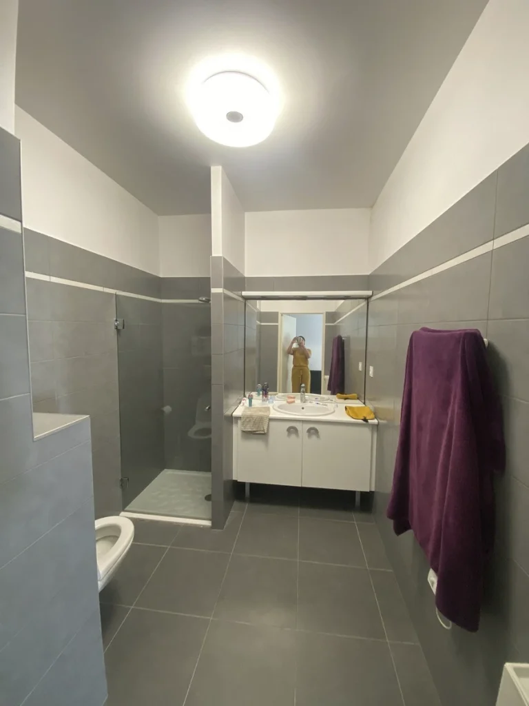 Salle d'eau avant travaux, carrelage gris et douche, projet Parengon par Maison Solthée, architecte d'intérieur à Marseille