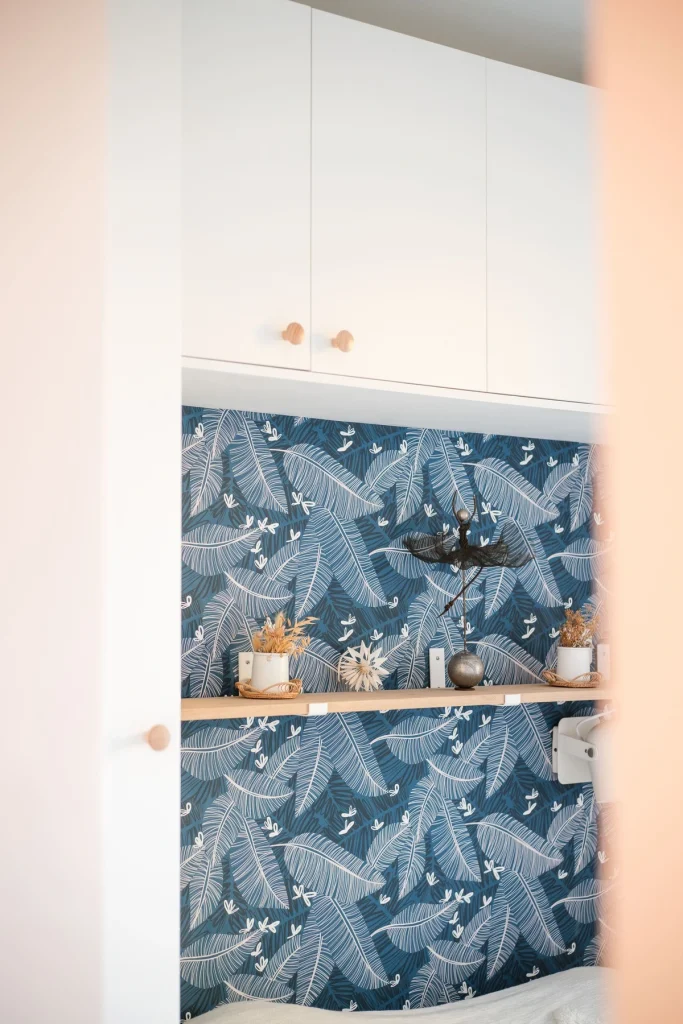 Papier peint bleu nuit à motif feuillage avec étagère et meuble blanc, projet Val Saint-Jean par Maison Solthée, architecte d'intérieur à Aix-en-Provence