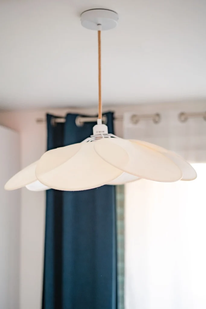 Suspension en pétales de papier crème devant des rideaux bleu marine, projet Val Saint-Jean par Maison Solthée, architecte d'intérieur à Aix-en-Provence