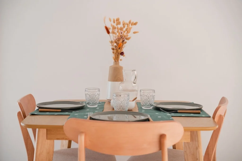 Table à manger dressée avec chaises en bois et fleurs séchées, projet Val Saint-Jean par Maison Solthée, architecte d'intérieur à Aix-en-Provence