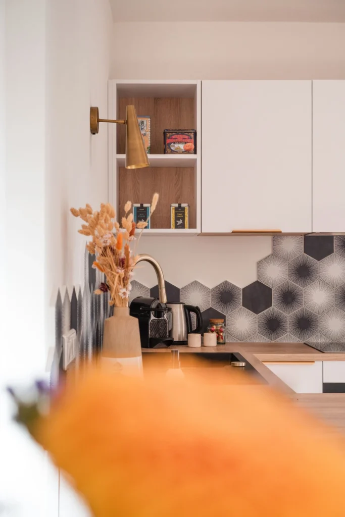 Cuisine blanche avec crédence en carreaux hexagonaux gris et bouquet séché, projet Val Saint-Jean par Maison Solthée, architecte d'intérieur à Aix-en-Provence