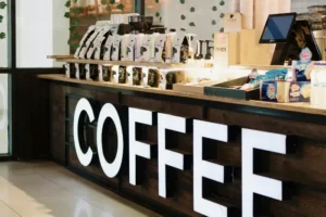 Comptoir de coffee shop avec lettres lumineuses COFFEE et présentoirs de café