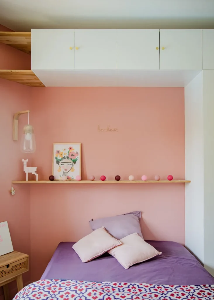 Chambre rose poudré avec lit, étagère en bois et placards hauts blancs, projet Barnabé par Maison Solthée, architecte d'intérieur à Marseille