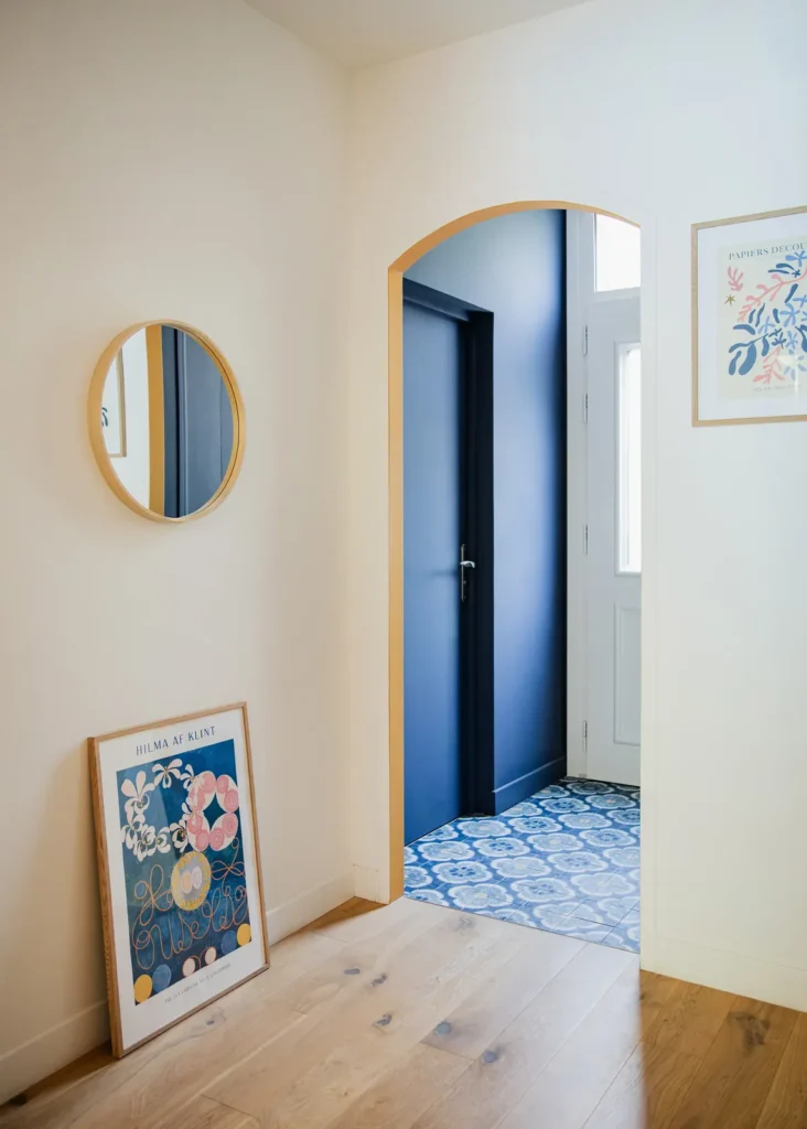 Entrée avec miroir rond, arche, porte bleu marine et carreaux de ciment, projet Barnabé par Maison Solthée, architecte d'intérieur à Marseille