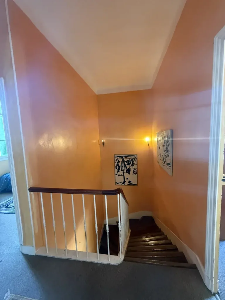 Escalier avant travaux, murs orange et balustrade blanche, projet Barnabé par Maison Solthée, architecte d'intérieur à Marseille
