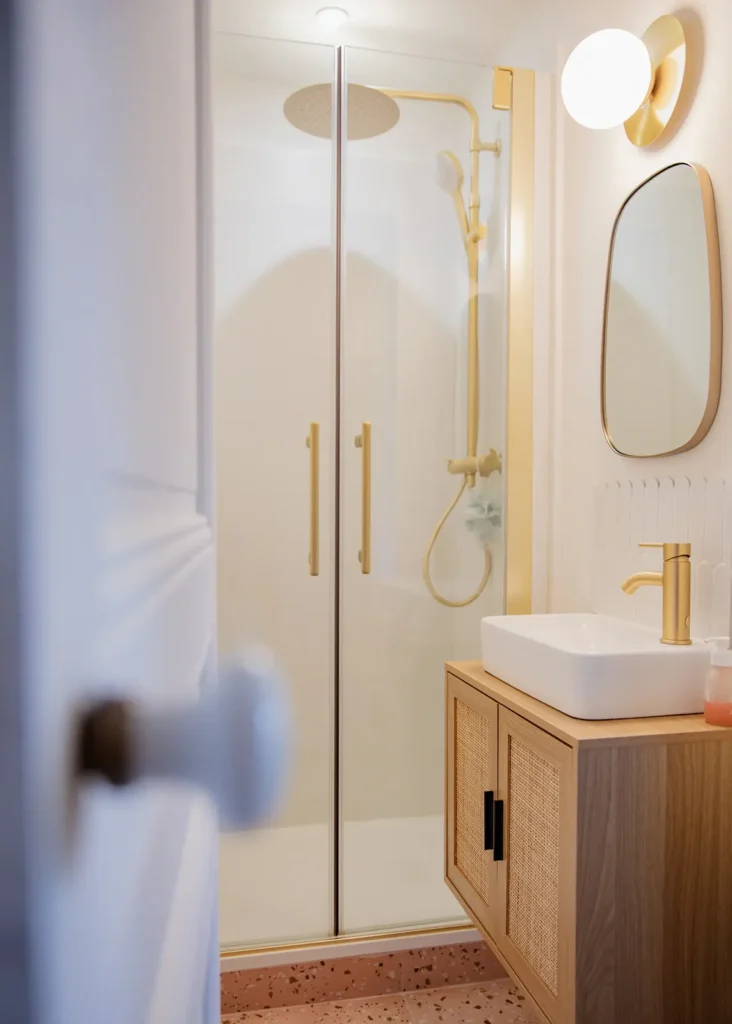 Salle d'eau avec douche vitrée à poignées dorées, vasque sur meuble bois, projet Barnabé par Maison Solthée, architecte d'intérieur à Marseille