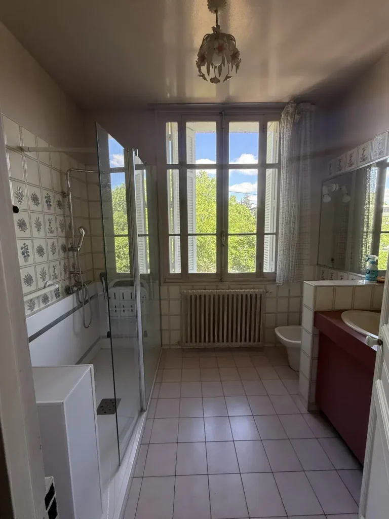 Salle de bain avant travaux, carrelage mural, radiateur et fenêtres, projet Barnabé par Maison Solthée, architecte d'intérieur à Marseille