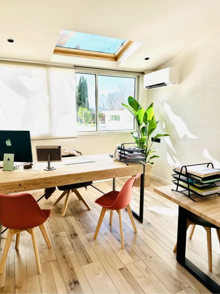Bureau en bois près de la fenêtre avec plante verte, projet Montaigne par Maison Solthée, architecte d'intérieur à Marseille