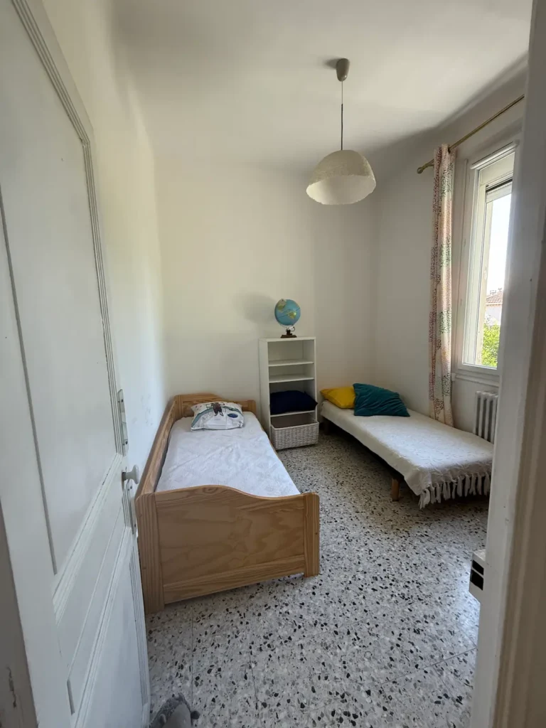 Avant travaux : chambre avec deux lits simples et sol en carrelage moucheté, projet Augustine par Maison Solthée, architecte d'intérieur à Cassis