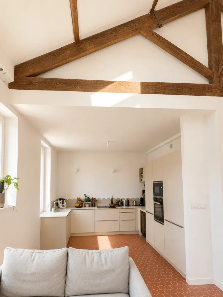 Séjour et cuisine ouverts sous charpente apparente, sol en carreaux hexagonaux terracotta, projet Augustine par Maison Solthée, architecte d'intérieur à Cassis